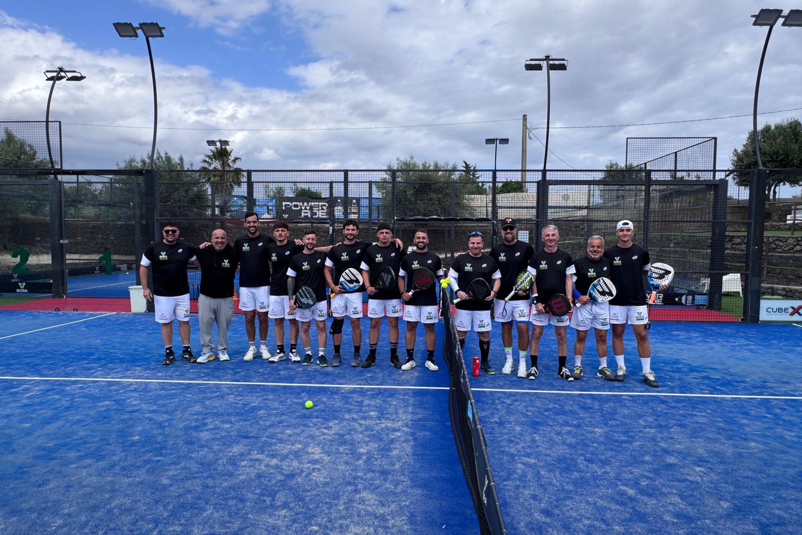 Gruppo di giocatori schierati sui campi blu in un giorno di torneo